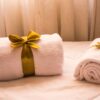 pexels-photo-1304110-1304110 Luxurious white towels adorned with golden ribbons on a bed, creating an elegant and welcoming atmosphere.