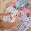 A joyful baby on the beach with parent, enjoying playtime on a sunny day.