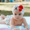 pexels-photo-14243394-14243394 Cute baby in a floral turban lying on a blanket outdoors.