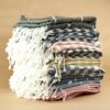 pexels-photo-30982437-30982437 A neatly stacked pile of colorful striped Turkish towels with fringe details.