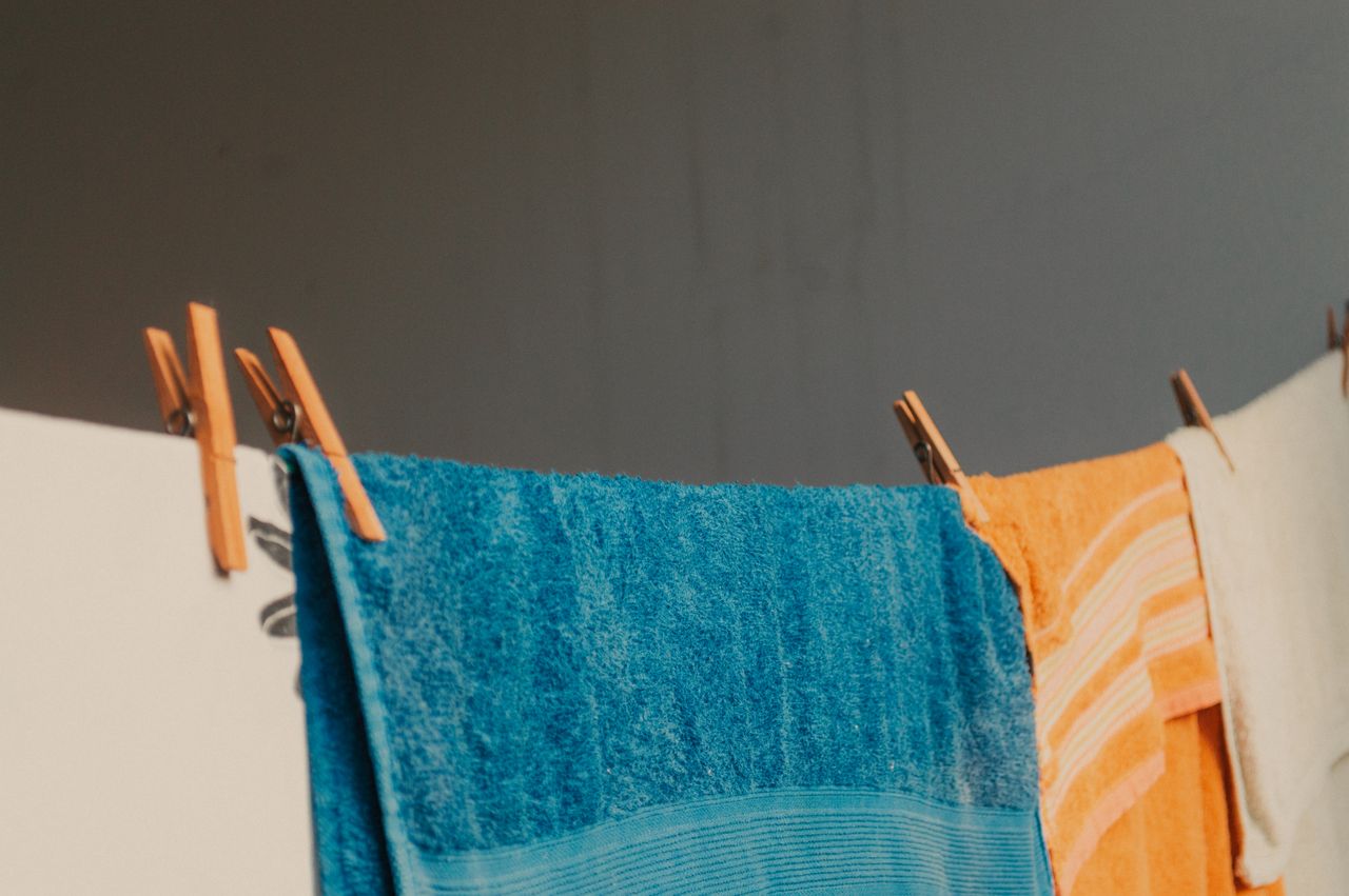 Vibrant towels clipped on a clothesline indoors create a homely feel.