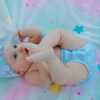 pexels-photo-8773748-8773748 Cute baby in a blue outfit playing on a colorful star-patterned blanket.